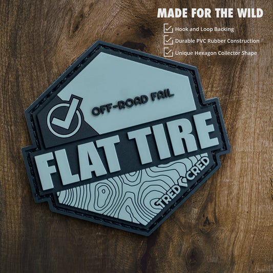 Tred Cred Flat Tire PVC patch with off-road topography design and hook and loop backing on a grey background.