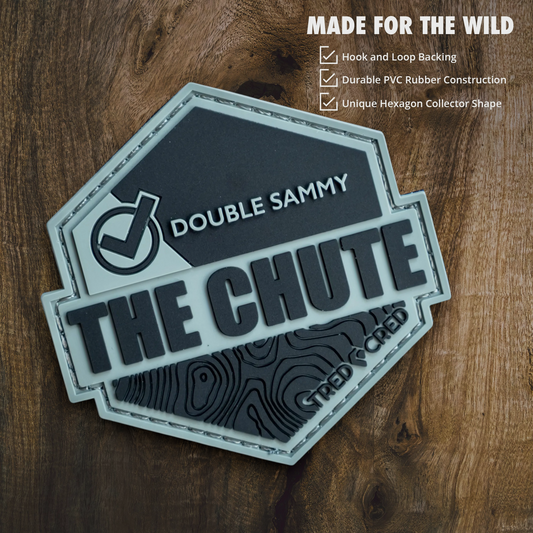 Tred Cred The Chute hexagon PVC rubber trail patch with hook and loop backing on a wooden background