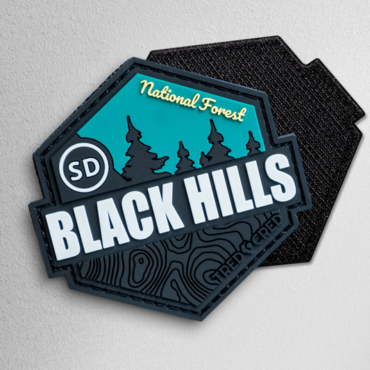 Tred Cred Black Hills National Forest PVC patch with teal and black design, featuring SD and topographic details.