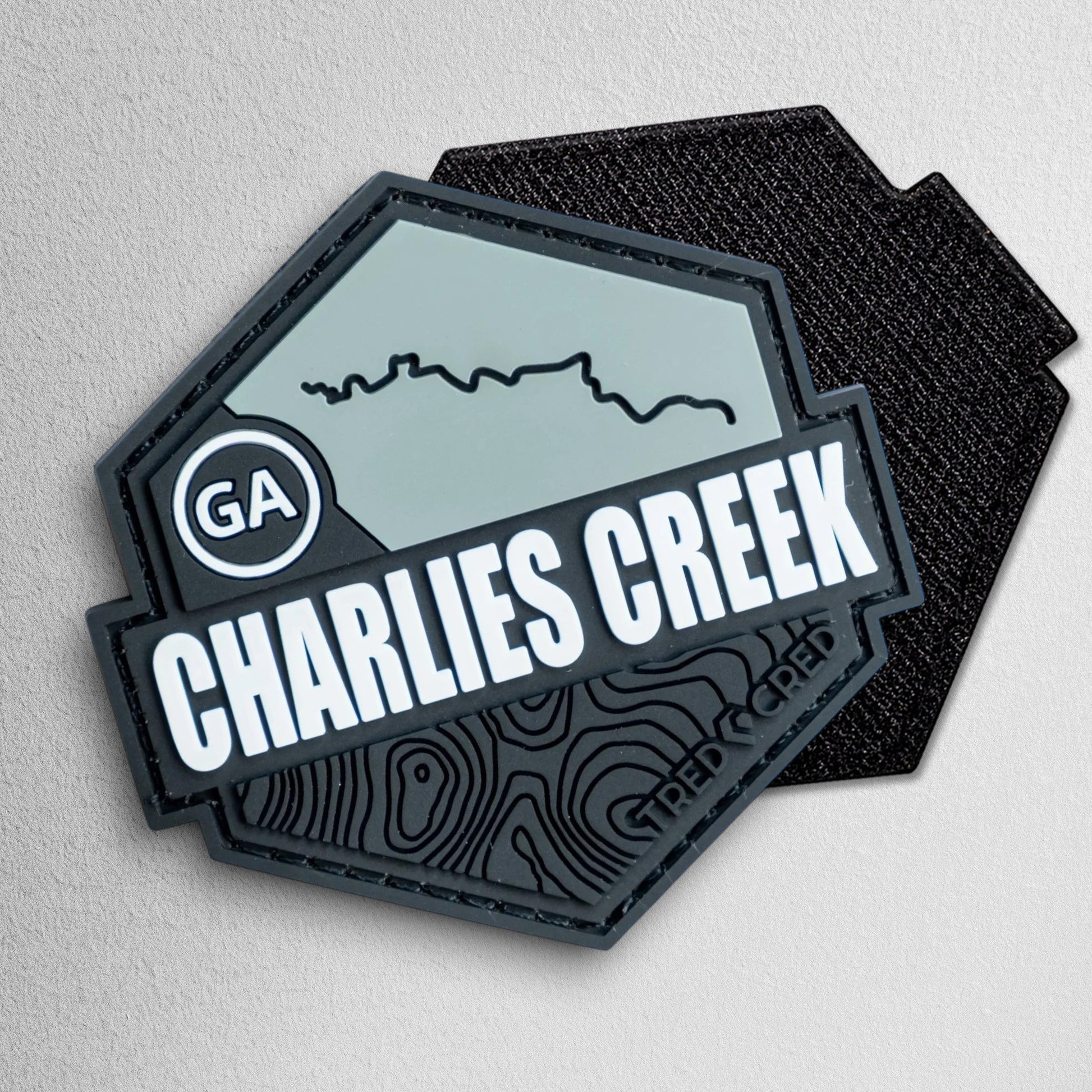 Tred Cred Charlies Creek hexagonal PVC trail patch in grey and black with GA state and topographical map details.