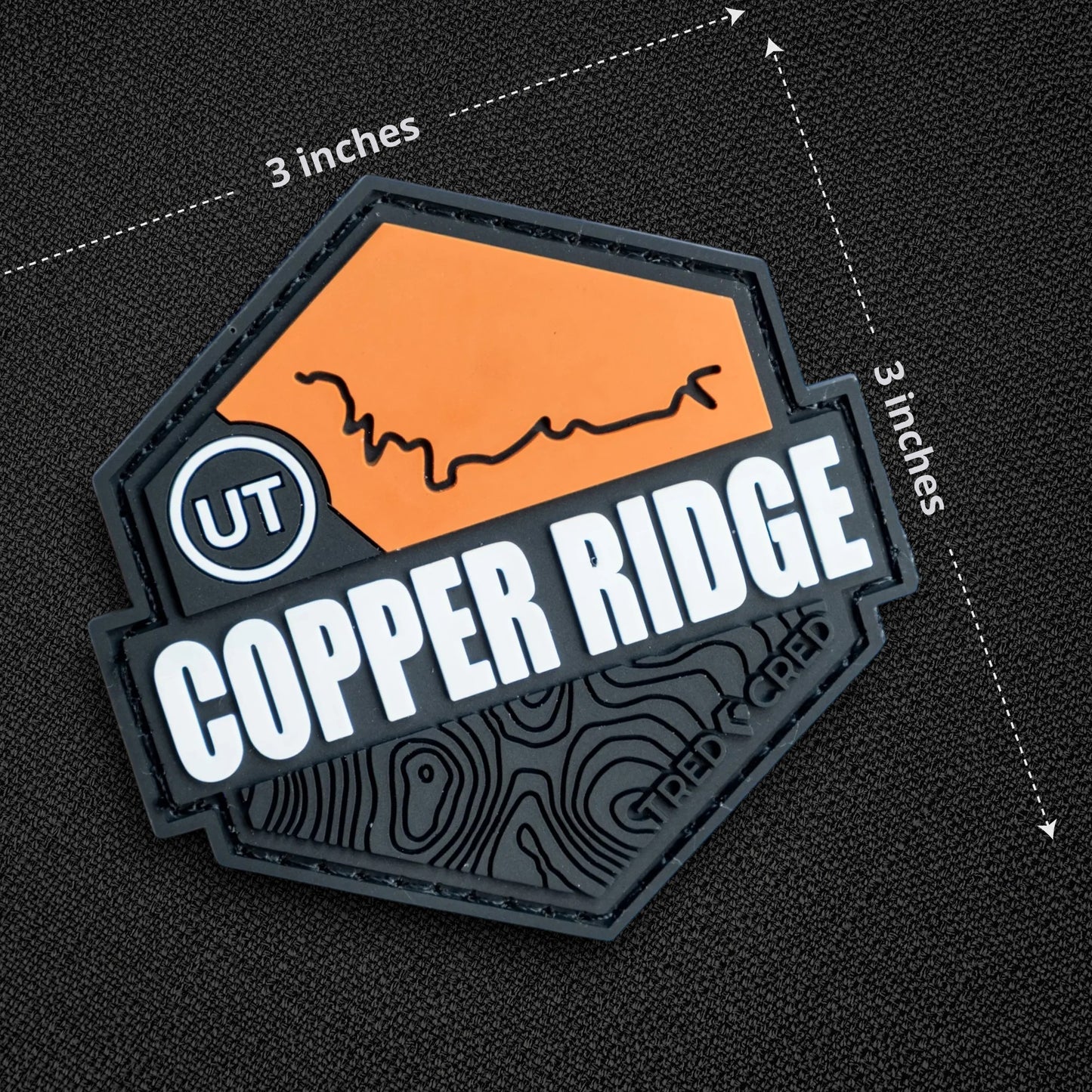 Tred Cred Copper Ridge PVC trail patch with orange and black topographic design and hook and loop backing