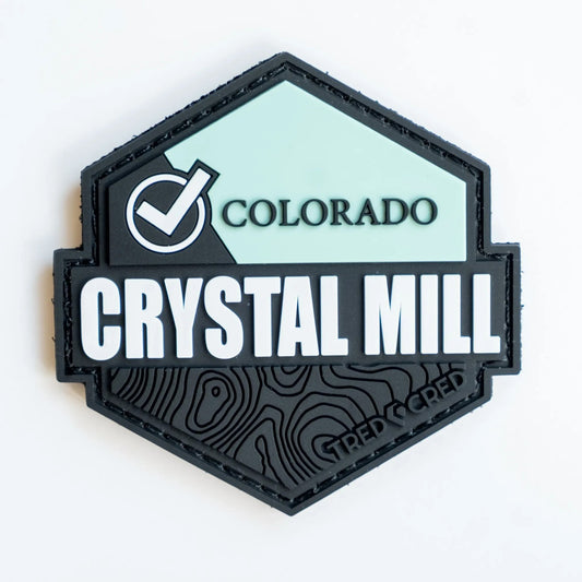 Tred Cred Crystal Mill PVC rubber trail patch with a hexagonal shape, mint green accent, and topographic map detail.