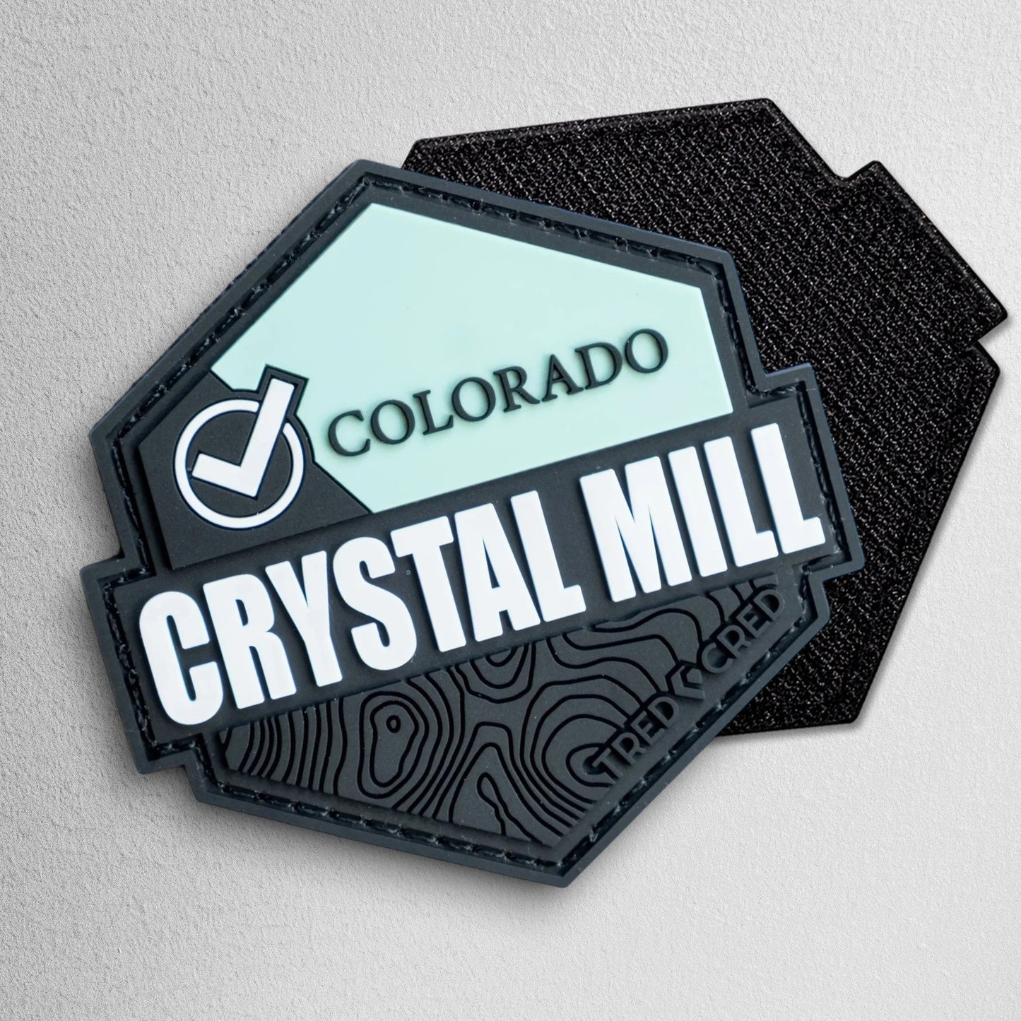 Tred Cred Crystal Mill hexagonal PVC trail patch with topographic map detail and hook and loop backing