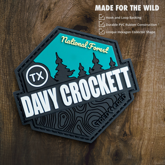 Tred Cred Davy Crockett National Forest hexagon PVC patch with teal and black topographic design on wood background