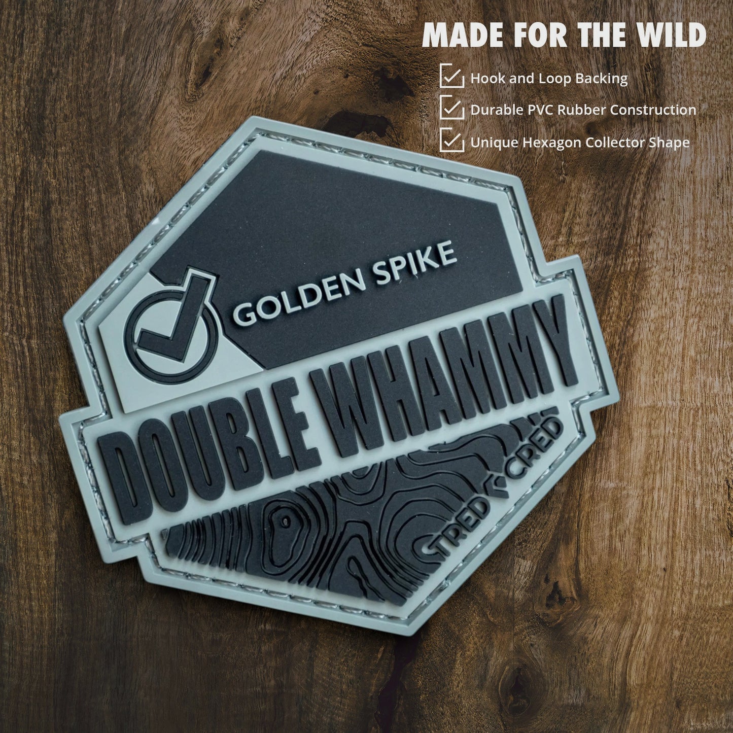 Tred Cred Double Whammy hexagon PVC rubber trail patch with hook and loop backing on a wooden background