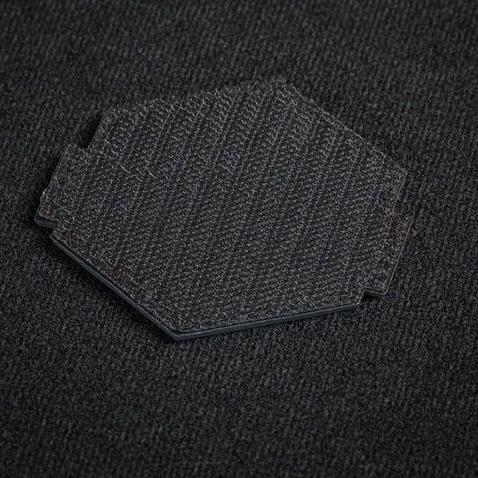 Tred Cred Escalator trail patch showing the black hook and loop backing on a textured fabric surface