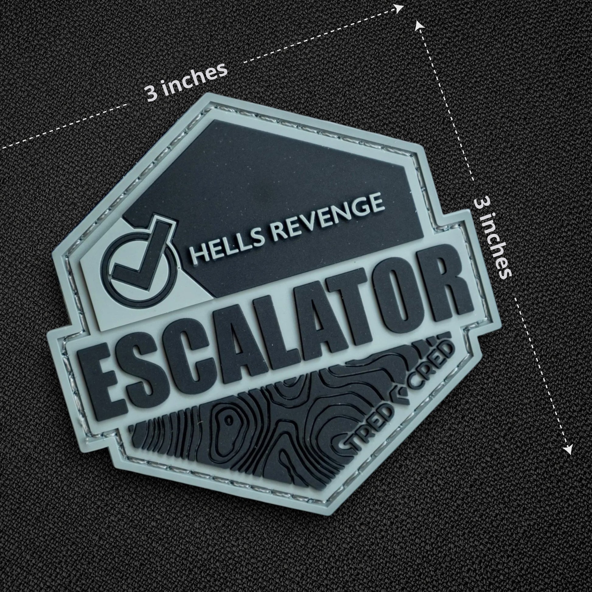 Tred Cred Escalator trail patch in grey and black PVC rubber with Hells Revenge text and topographic map design