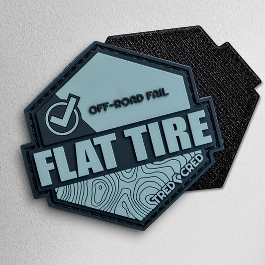 Tred Cred Flat Tire PVC patch in grey and black with a topographic map design and hook and loop backing.