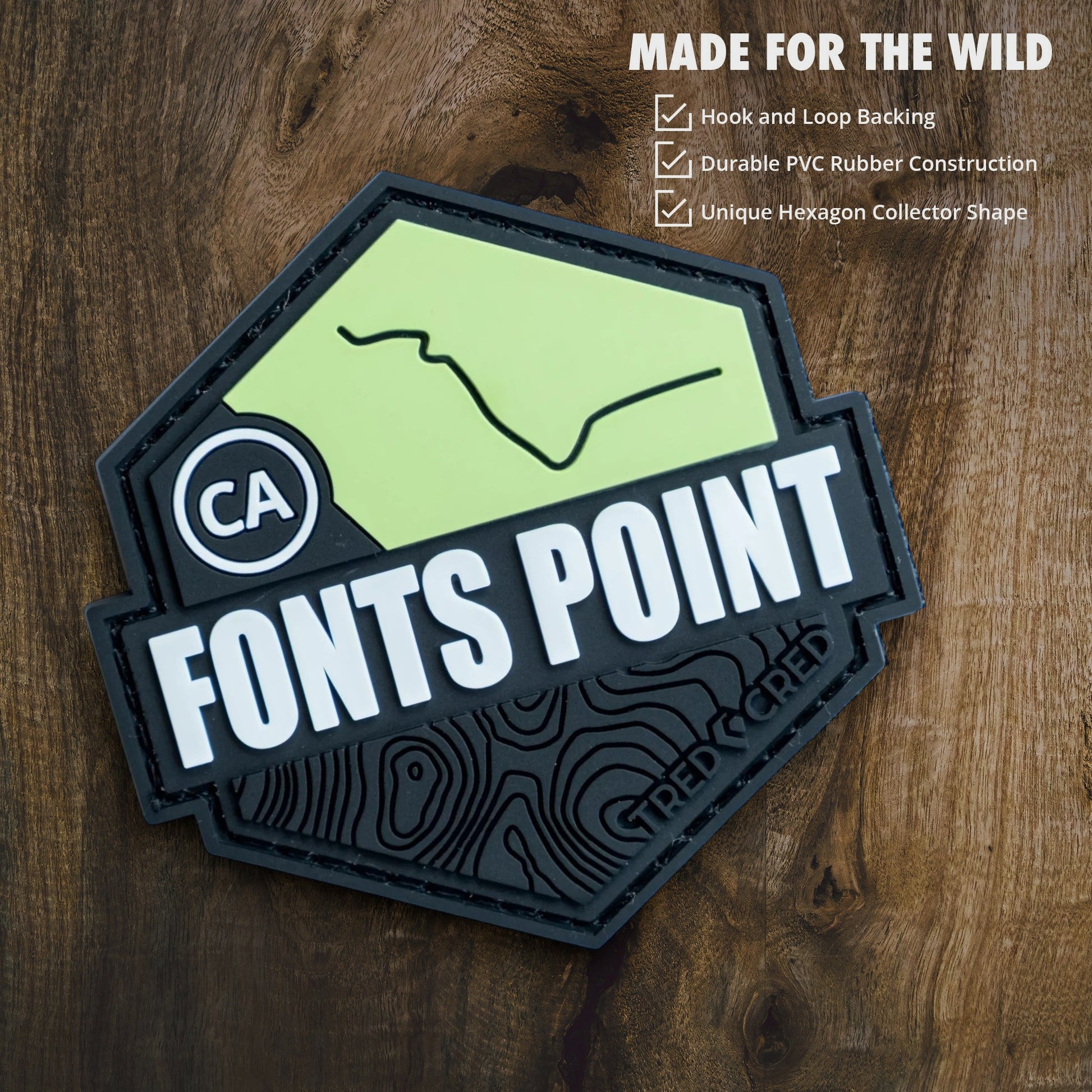 Tred Cred Fonts Point hexagon PVC trail patch with hook and loop backing on a wooden background