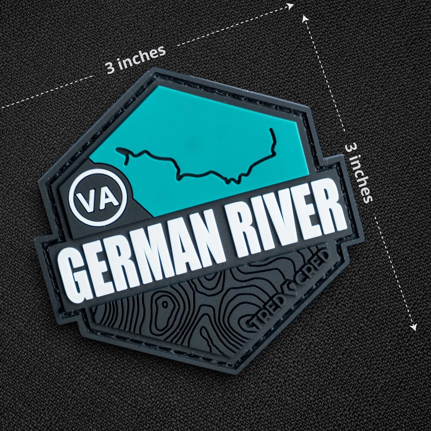 Tred Cred German River trail patch in teal and black PVC rubber with hook and loop backing, 3x3 inch hexagonal shape.