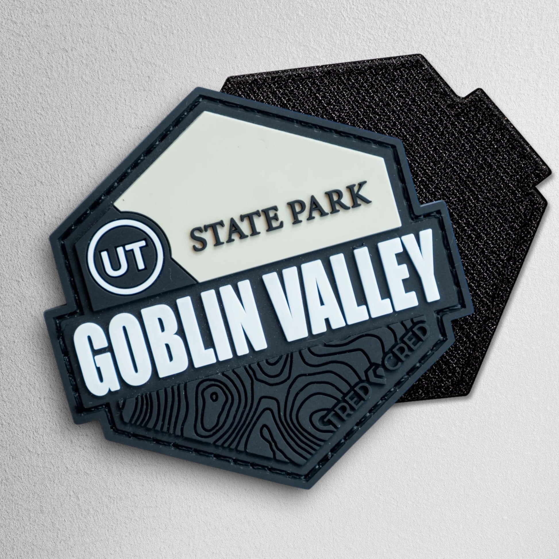 Tred Cred Goblin Valley State Park hexagonal PVC patch with black and cream topographic design and hook backing.