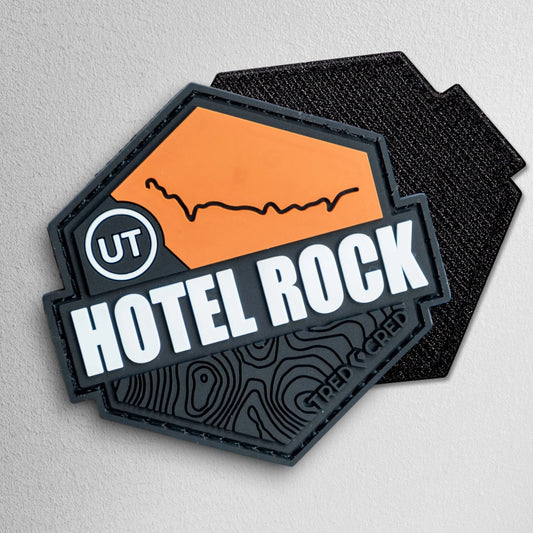 Tred Cred Hotel Rock PVC trail patch with orange and black topographic design and hook and loop backing