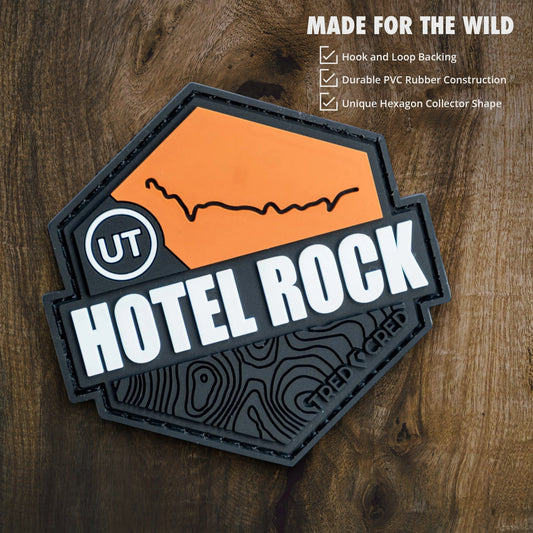 Tred Cred Hotel Rock PVC trail patch with orange and black topographic design and hook and loop backing.