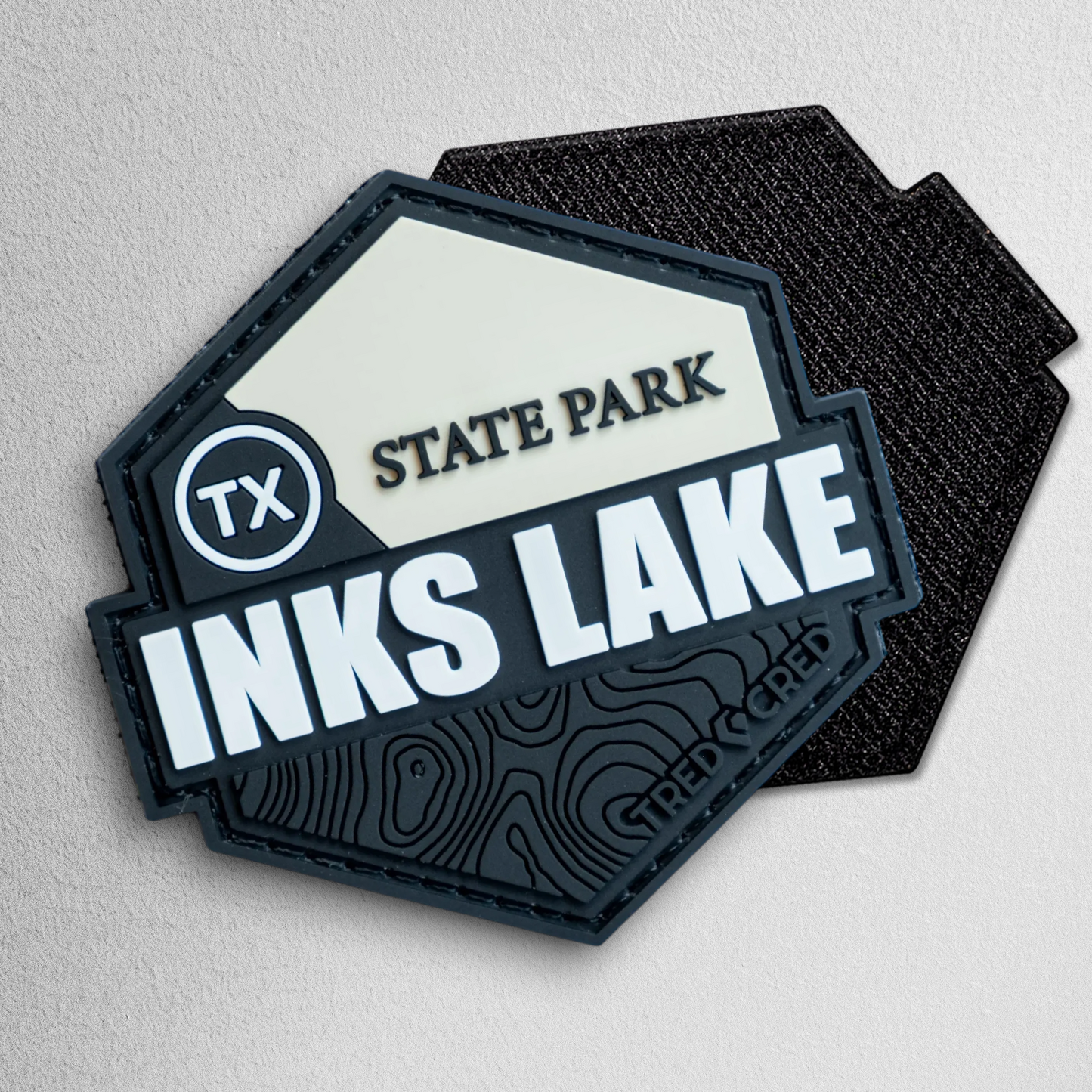 Tred Cred Inks Lake State Park hexagonal PVC patch with black and cream topographic design and hook-and-loop backing.
