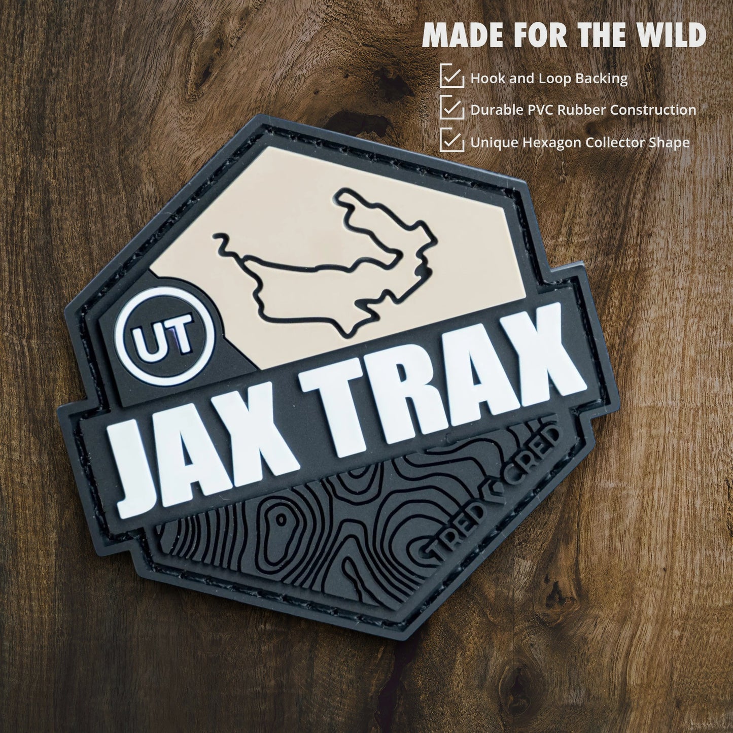 Tred Cred Jax Trax hexagon PVC patch with hook and loop backing, featuring a topographic map design in black and tan.