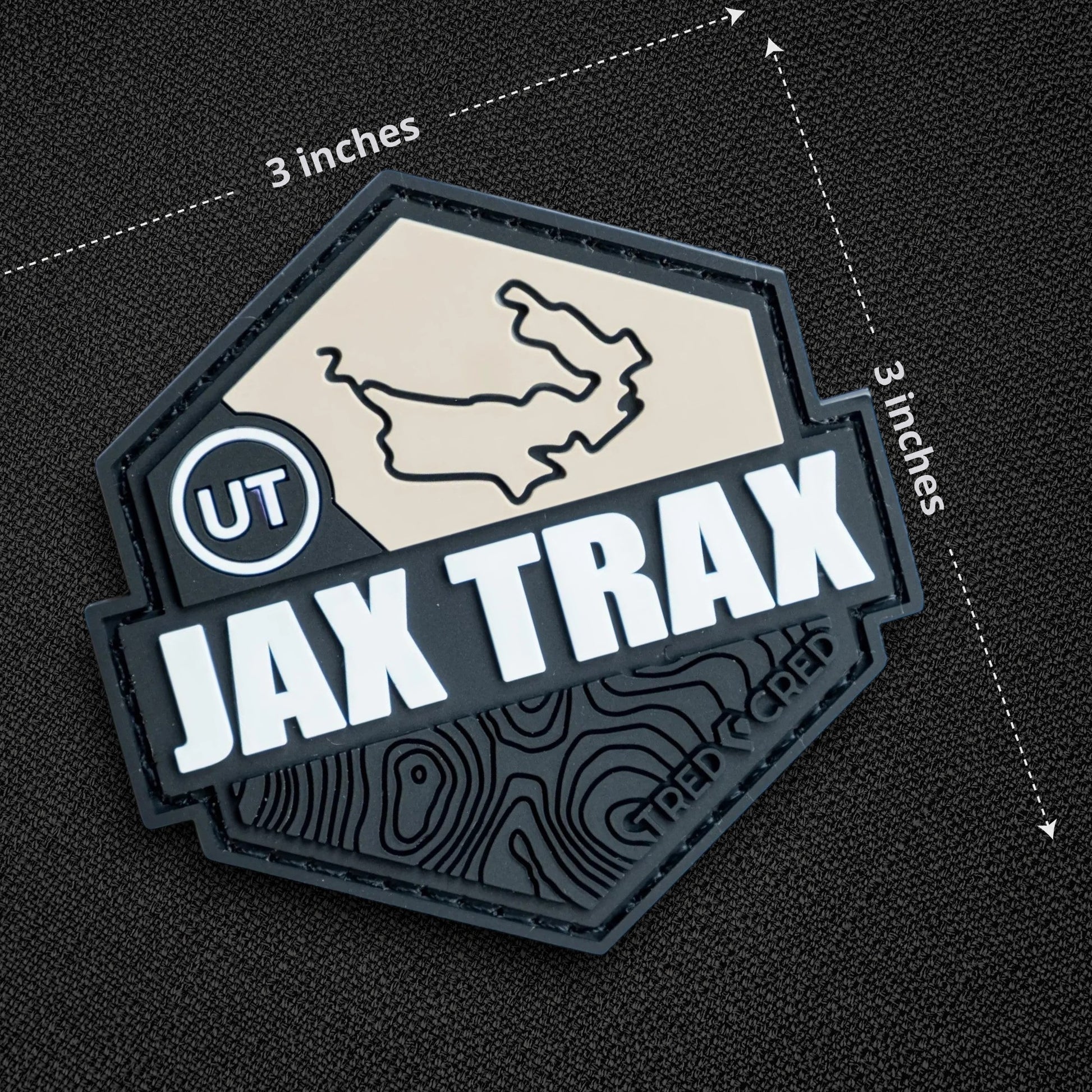 Tred Cred Jax Trax 3x3 inch hexagonal PVC rubber trail patch with topographic map design and hook and loop backing.
