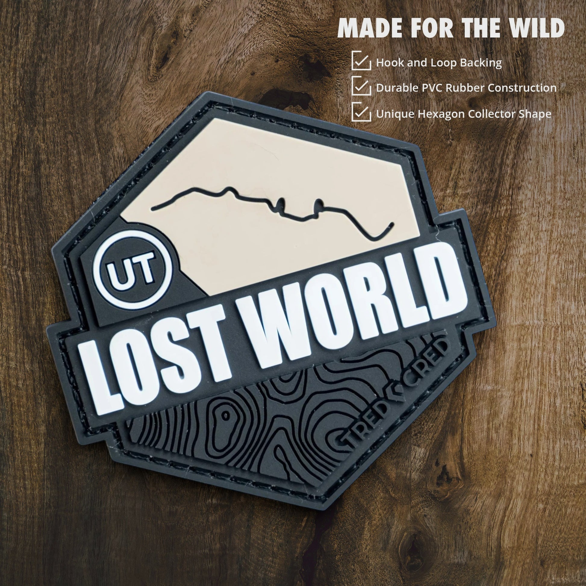 Tred Cred Lost World hexagon trail patch made of durable PVC rubber with hook and loop backing on wood background