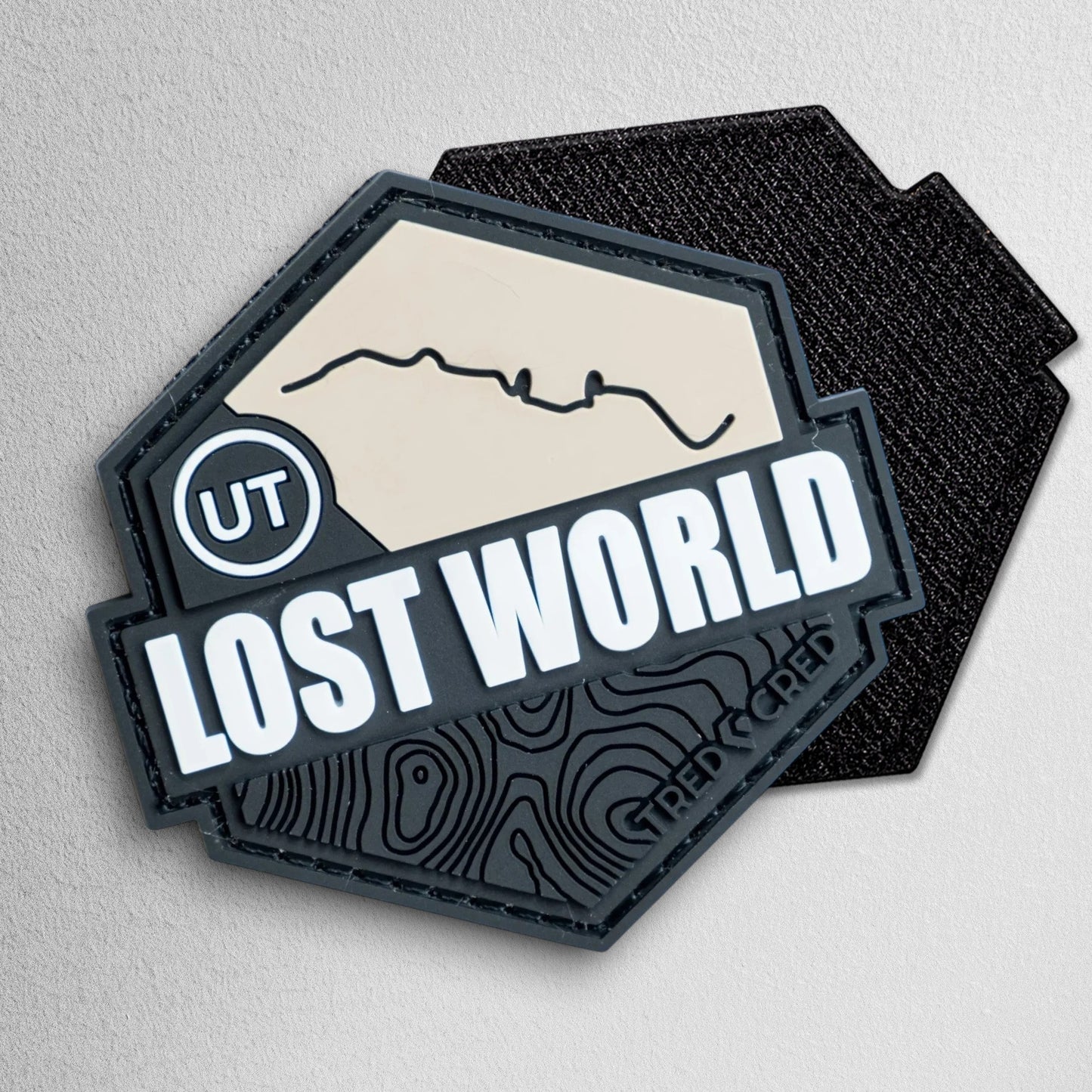 Tred Cred Lost World PVC trail patch with Utah map design, black and beige hexagonal badge with hook and loop backing.