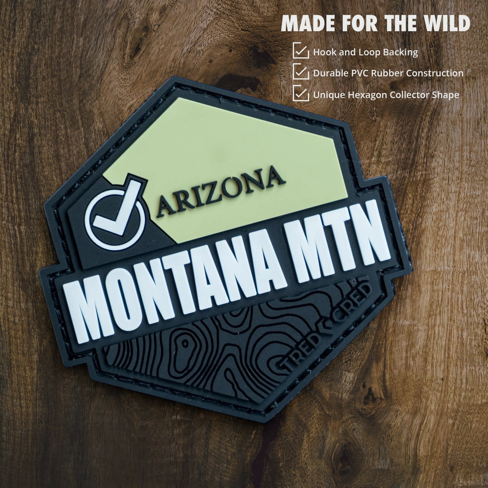 Tred Cred Montana Mountain hexagon PVC patch with hook and loop backing on a wooden surface