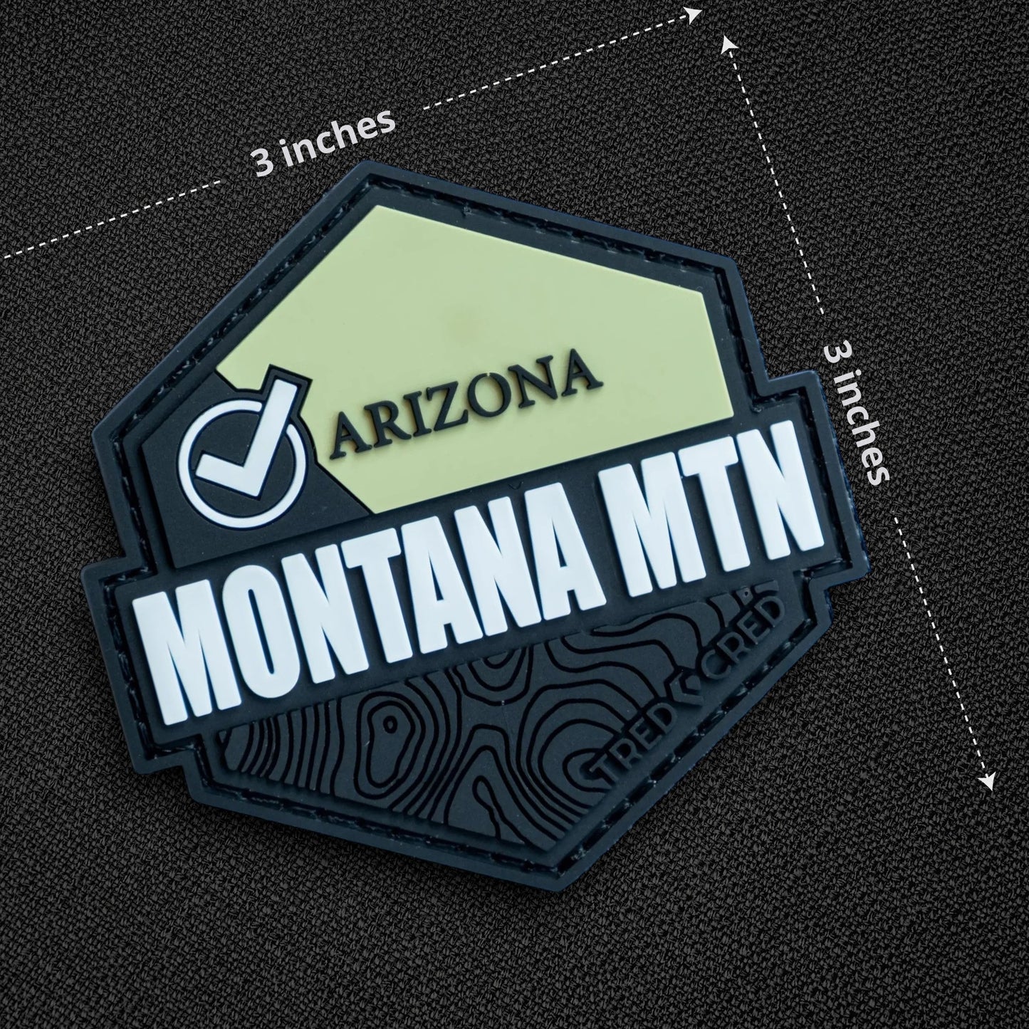Tred Cred Montana Mountain PVC patch with a hexagonal shape, light green and black design, and hook and loop backing.