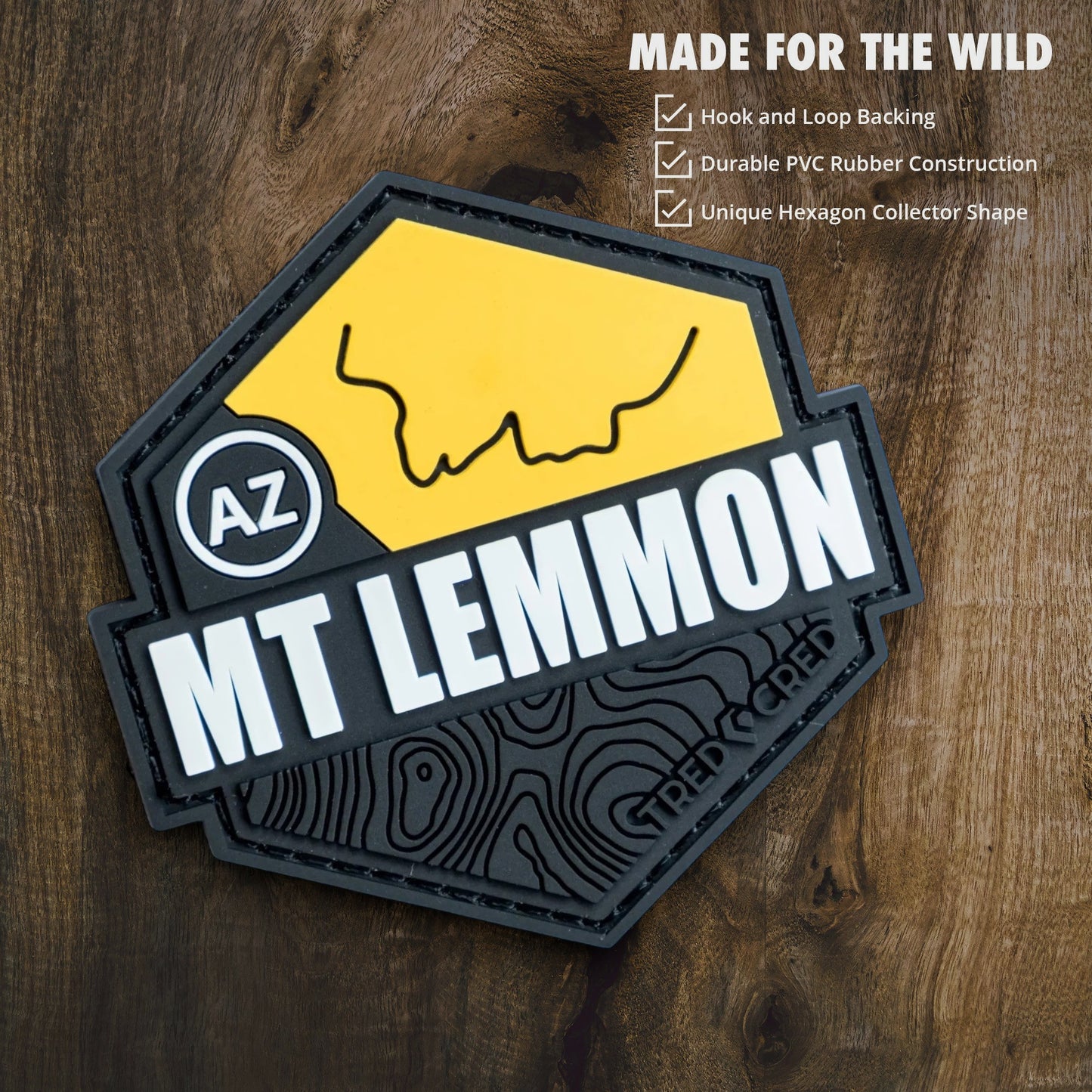 Tred Cred Mount Lemmon hexagon PVC rubber trail patch with hook and loop backing on a wooden background.
