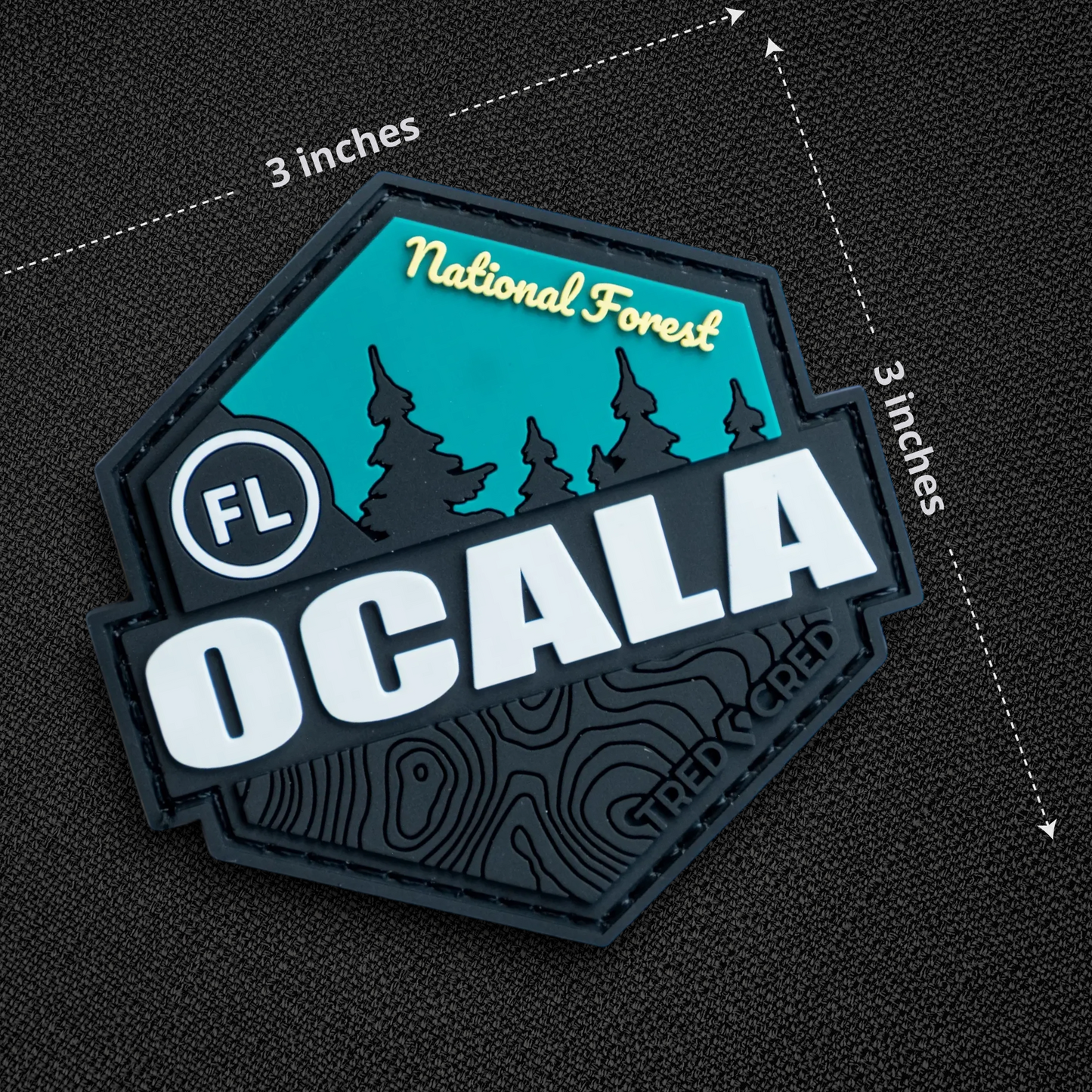 Tred Cred Ocala National Forest PVC patch with teal and black design, featuring forest silhouette and topographic map