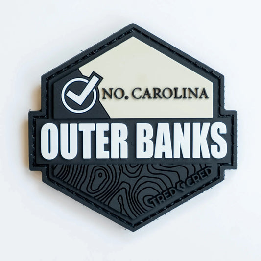 Tred Cred Outer Banks hexagonal PVC rubber trail patch with topographic map design and hook and loop backing.