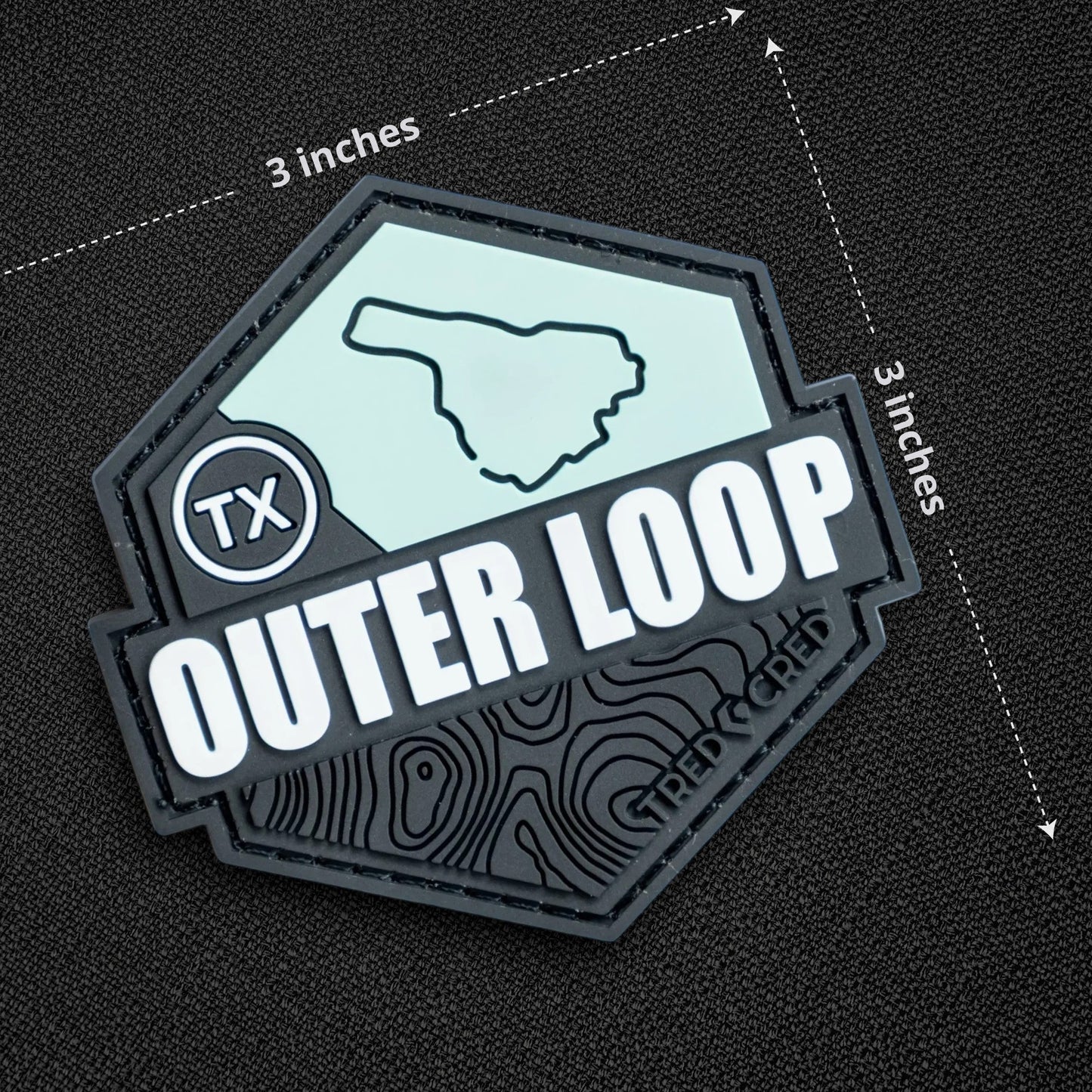 Tred Cred Outer Loop 3x3 inch hexagonal PVC trail patch with a light blue map design and black topographic details.