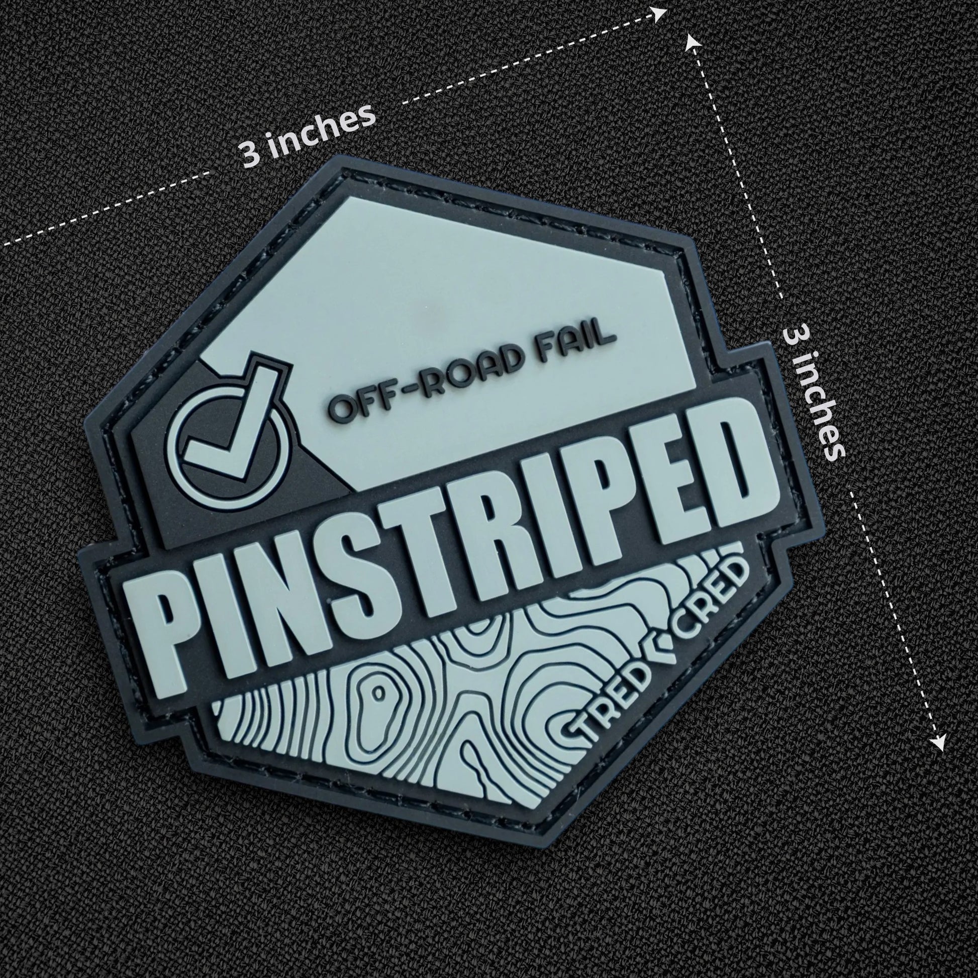 Tred Cred Pinstriped hexagonal PVC patch with off-road trail design and hook and loop backing on a white background.