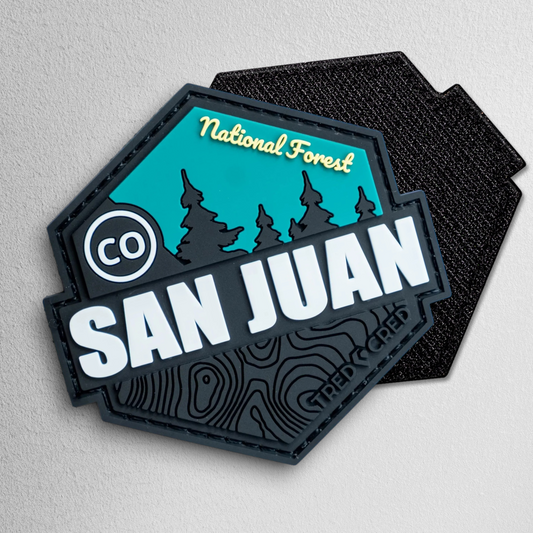 Tred Cred San Juan National Forest PVC patch with teal and black topographic design and hook and loop backing.