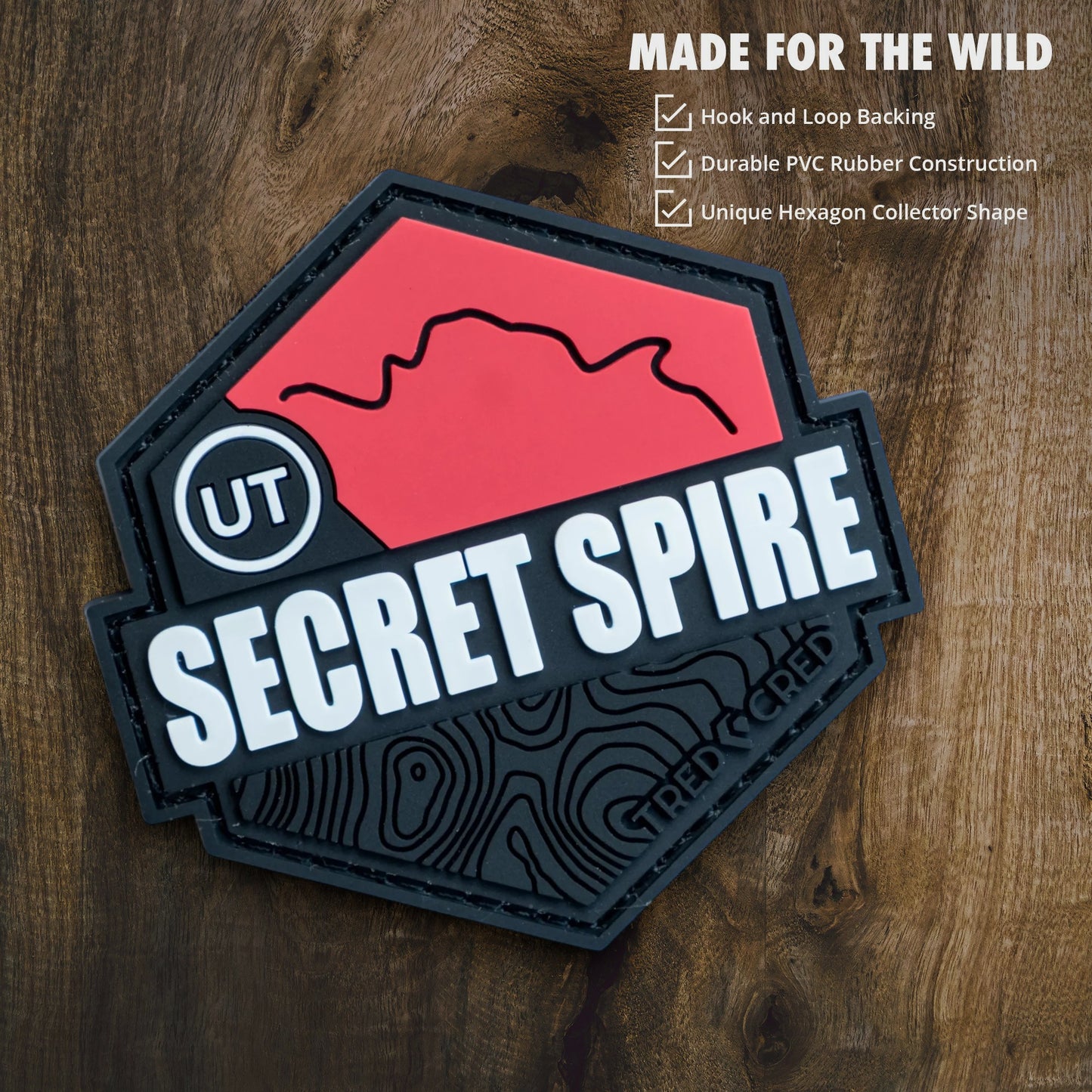 Tred Cred Secret Spire PVC trail patch with red and black topographical design and hook and loop backing