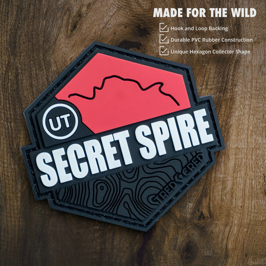 Tred Cred Secret Spire PVC trail patch with red and black topographical design and hook and loop backing