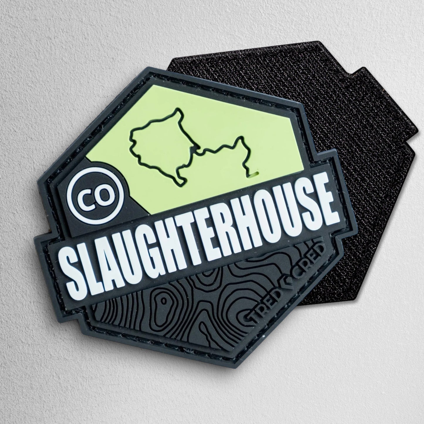 Tred Cred Slaughterhouse trail patch in black and lime green PVC rubber with a Colorado map and topographic design.