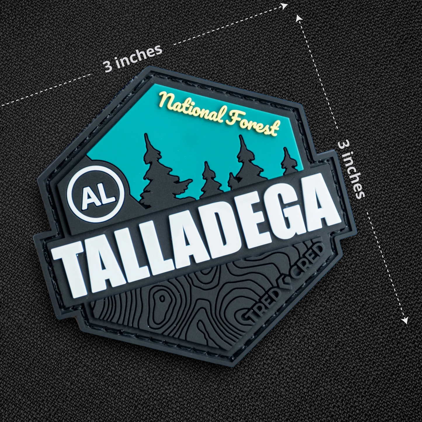 Tred Cred Talladega National Forest PVC patch with teal and black topographic design and hook and loop backing.