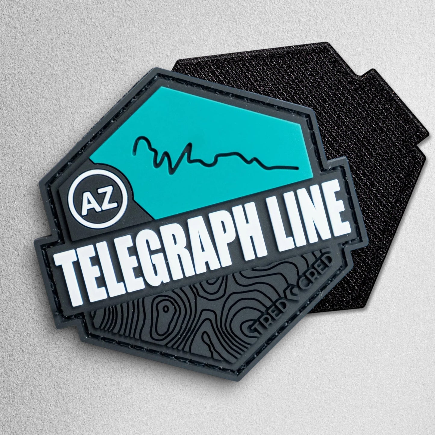 Tred Cred Telegraph Line hexagonal PVC trail patch in teal and black with AZ badge and topographic map details.