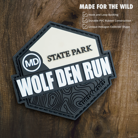 Tred Cred Wolf Den Run State Park hexagonal PVC patch with hook and loop backing on a wooden background