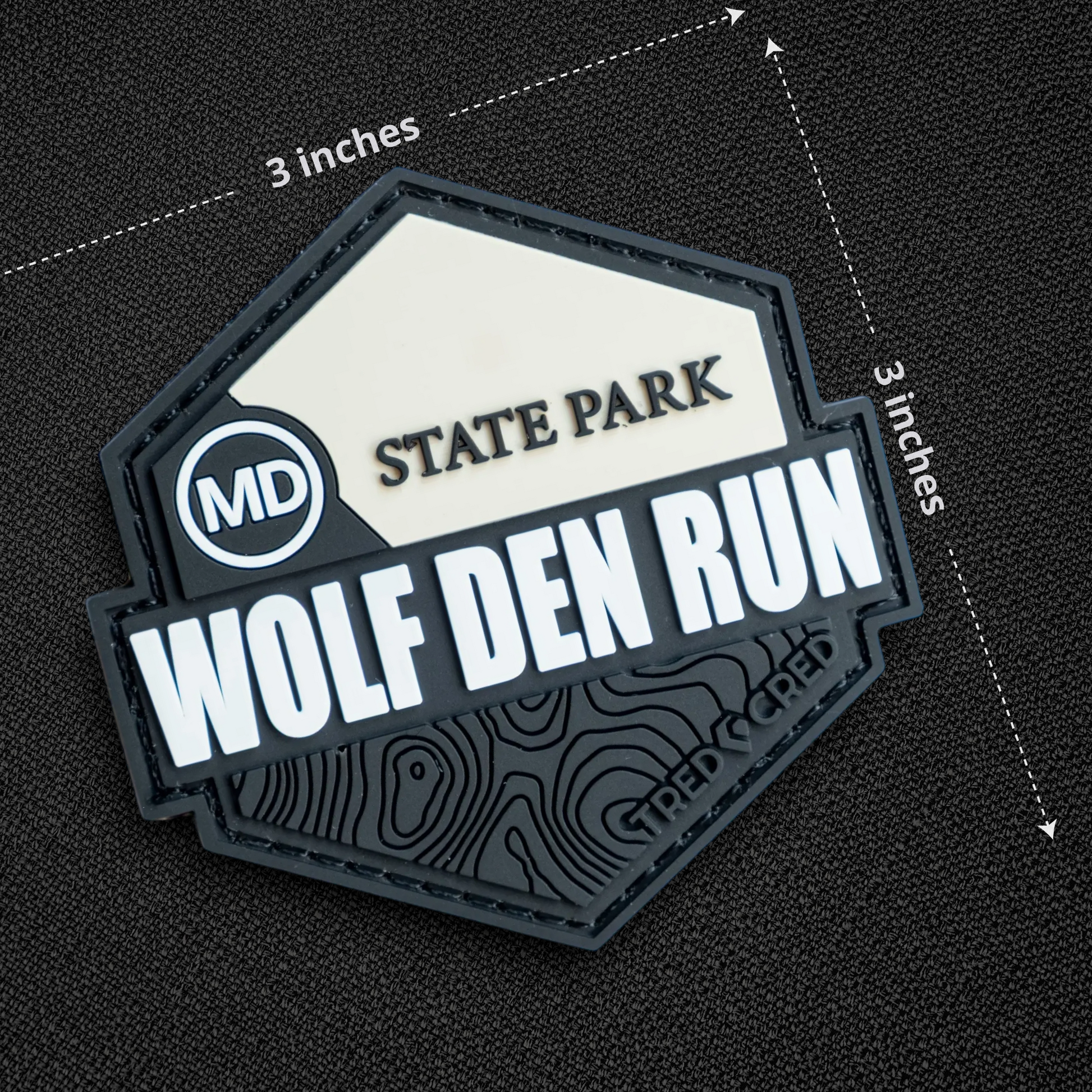 Tred Cred Wolf Den Run State Park PVC patch with hook and loop backing, featuring a topographic map design.
